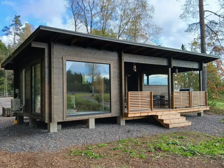 Viehättävä saunamökki, varustettuna terassilla ja mukavalla kuistilla.