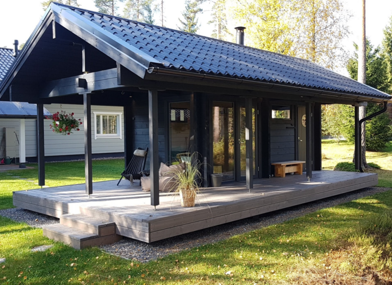 Viehättävä pihasauna, jossa on tilava terassi ja mukava kuisti.