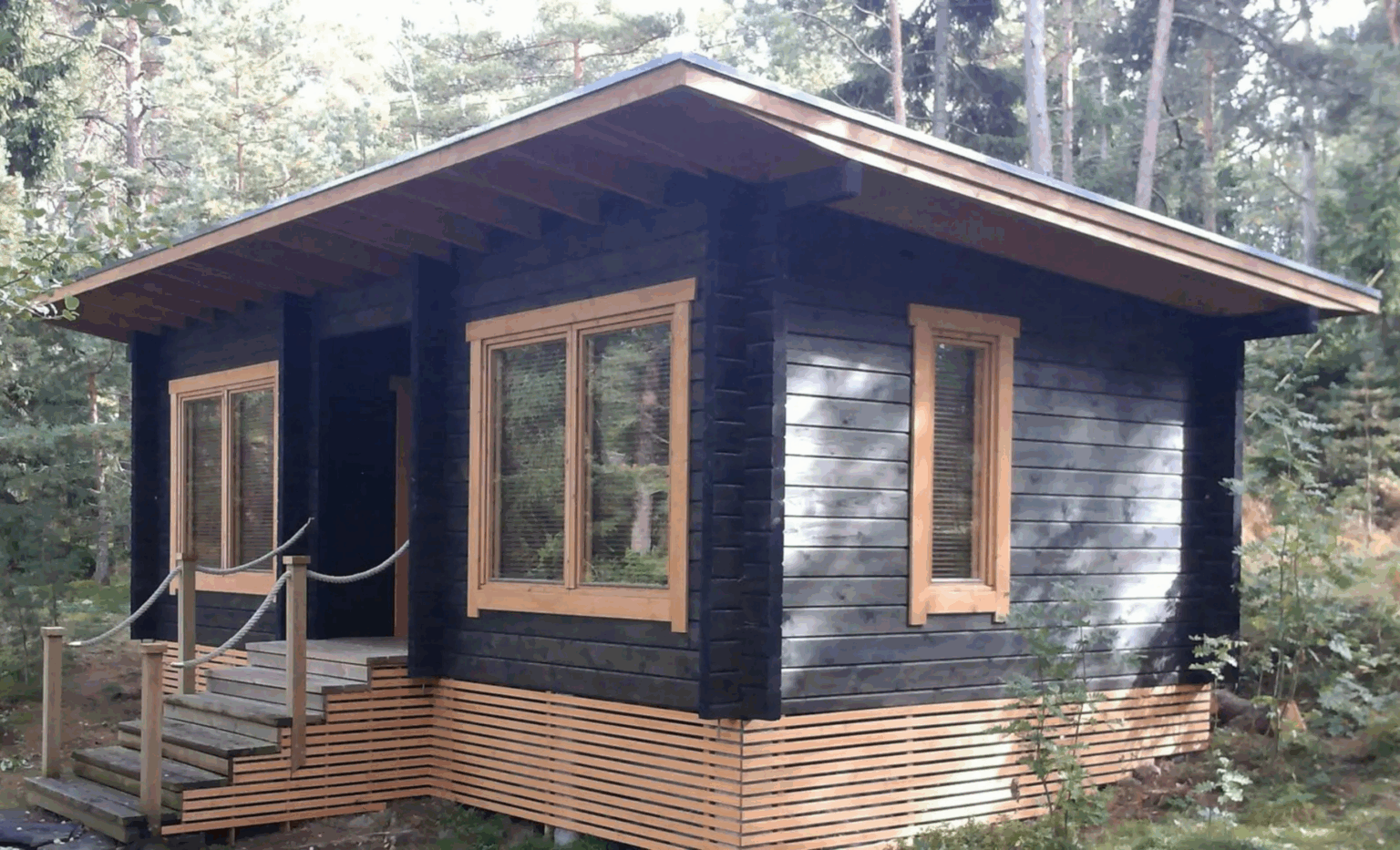 Vierasmajana toimiva hirsiaitta metsän uumeksessa