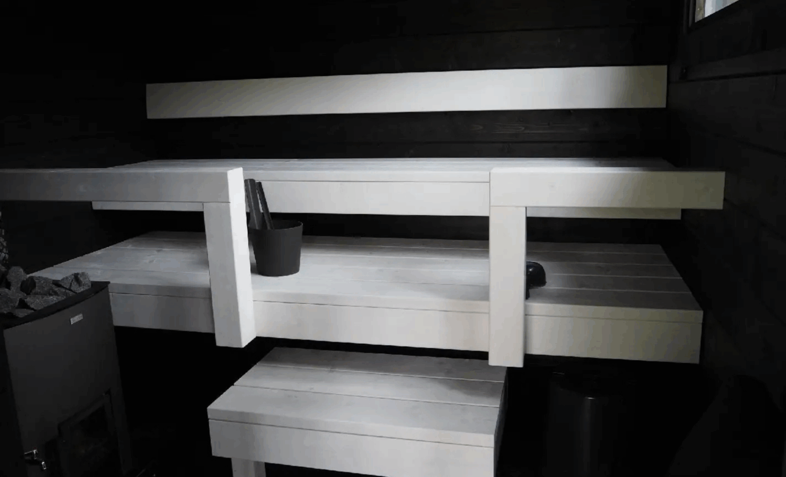 Pihasaunan saunatilat mustalla taustalla ja valkoisilla lauteilla