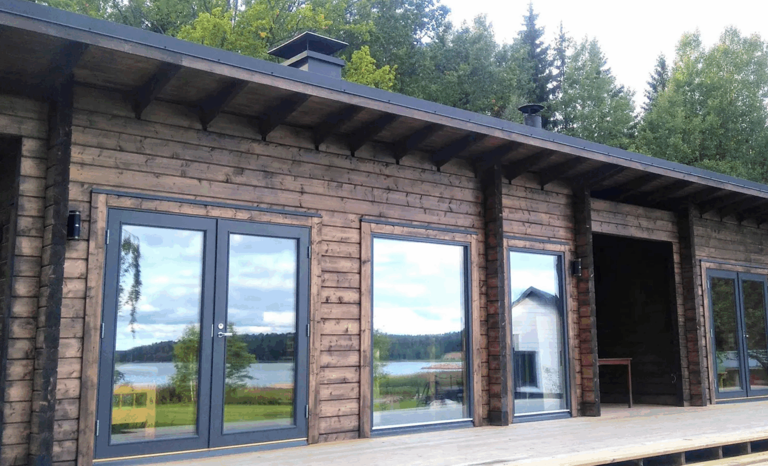 Hirsimökki terassilla ja ruskealla maalilla