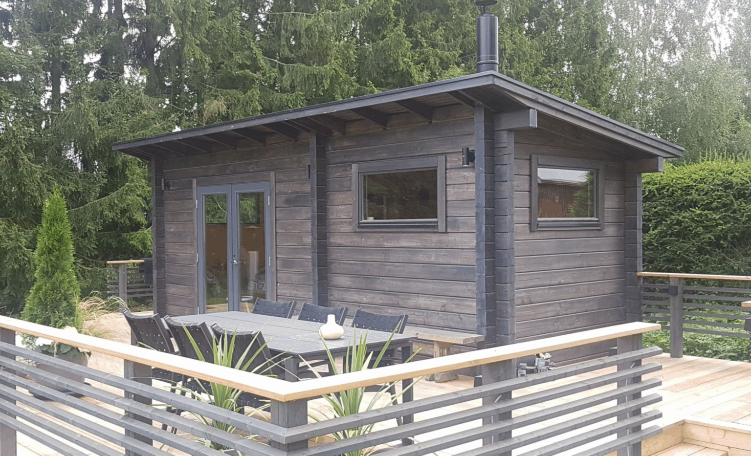 Ruskea valmismökki terassin päällä valmiina käyttöön