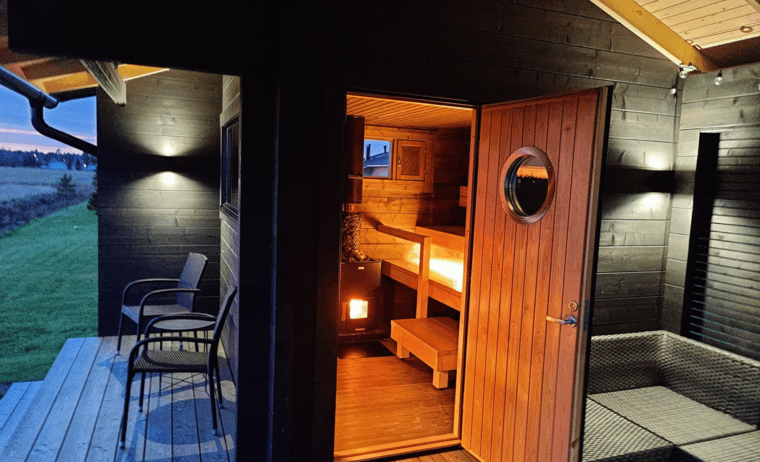 Näkymä saunatiloihin pihasaunan terassilta iltahämärässä